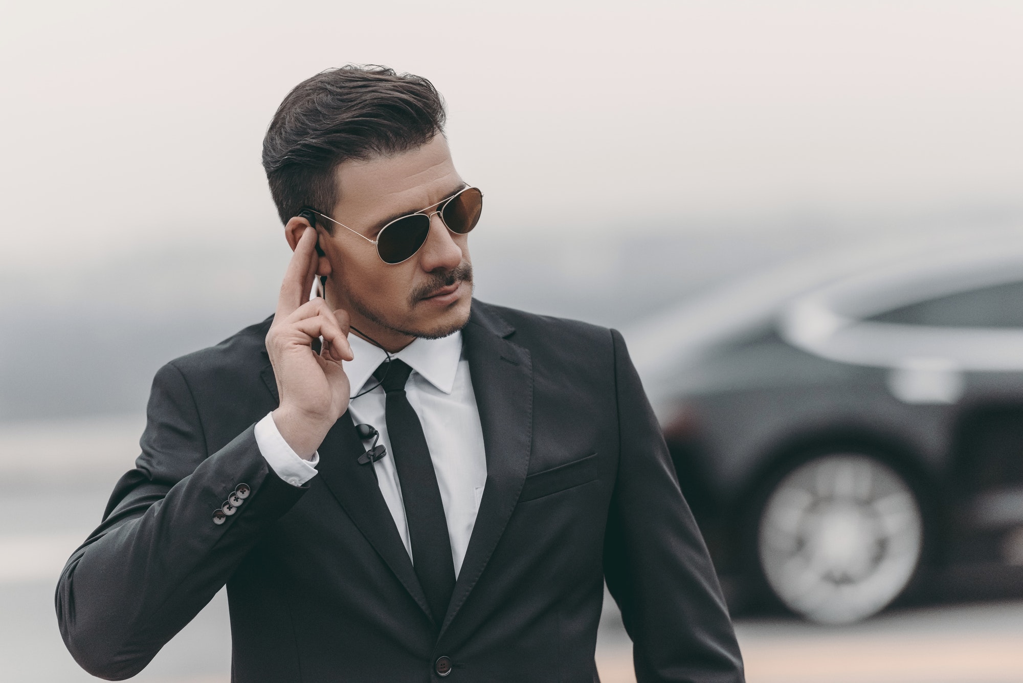 Bodyguard listening to a message through a security earpiece